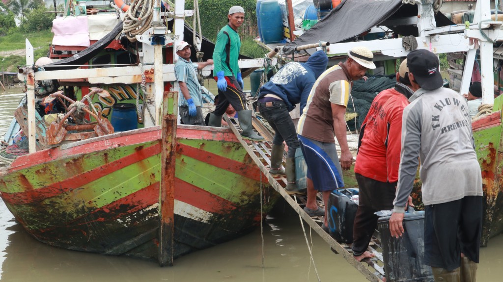 para pekerja perikanan sedang menyiapkan perbekalan sebelum berlayar